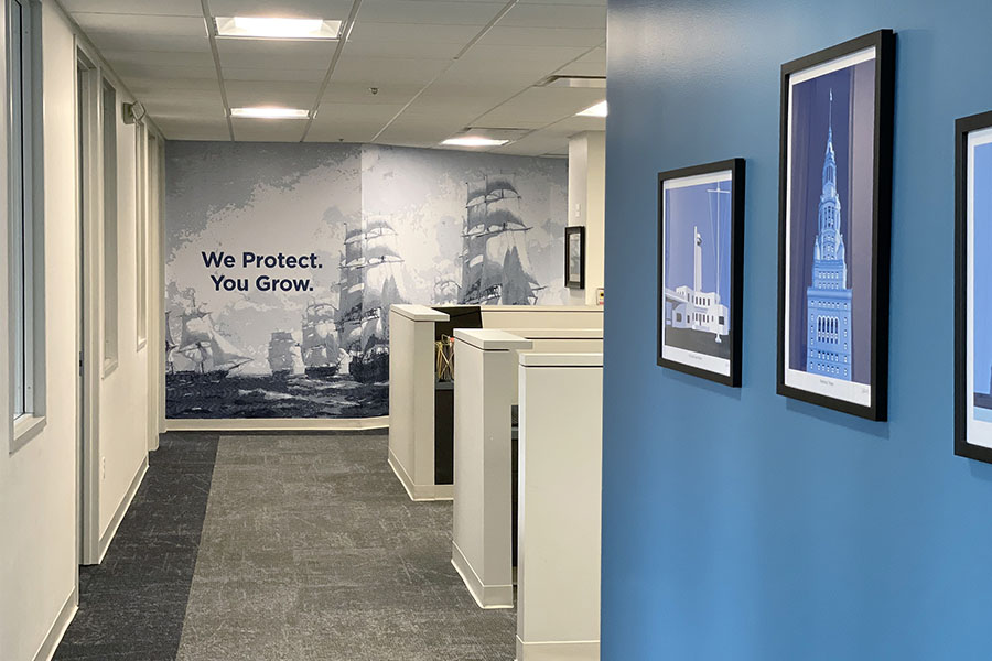 About Our Brokerage - View of a Hallway in the Armada Risk Partners Office Building with We Protect You Grow Tagline on Wall
